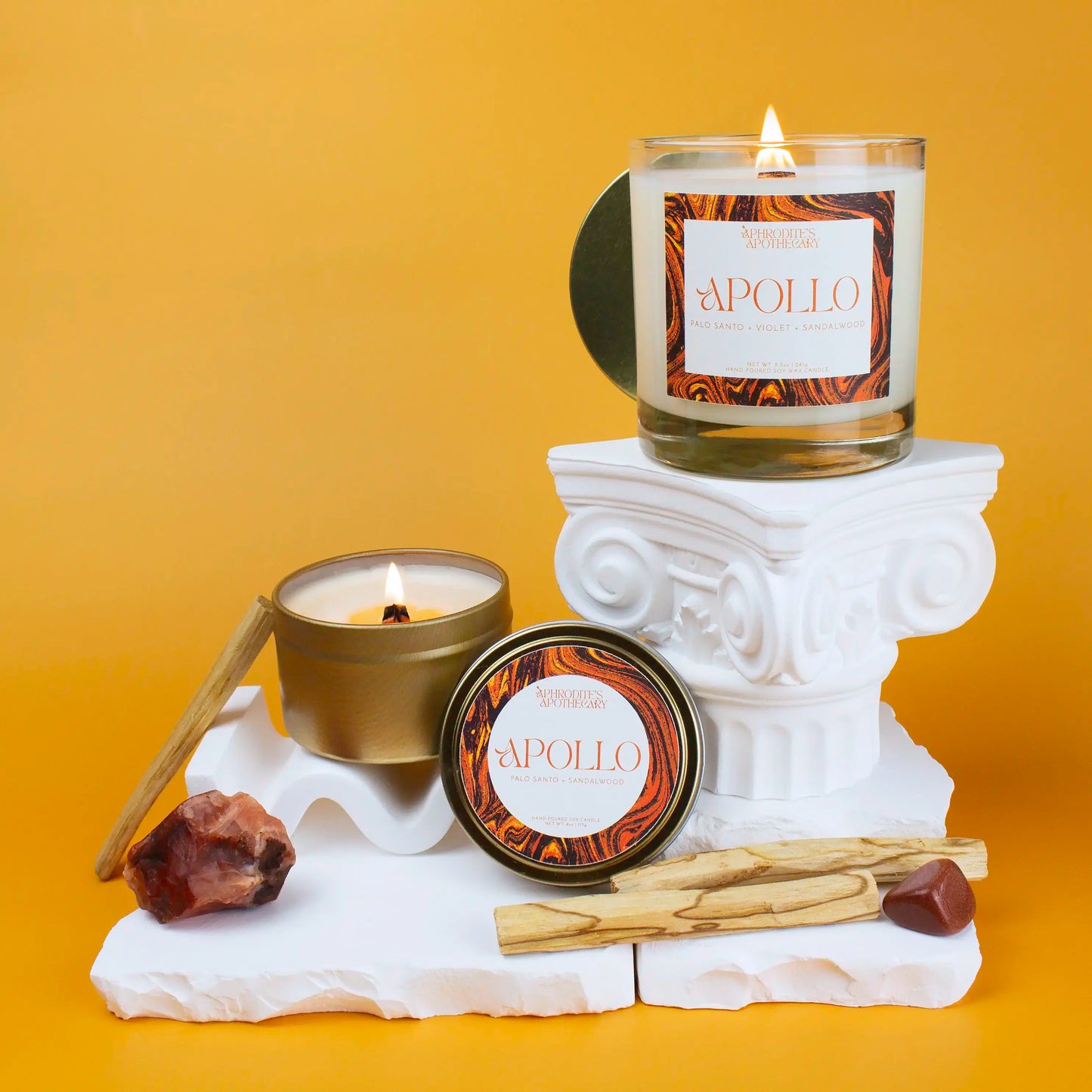 Aphrodite Candle 8.5 oz and 5 oz on a greek themed photo set with bright yellow background