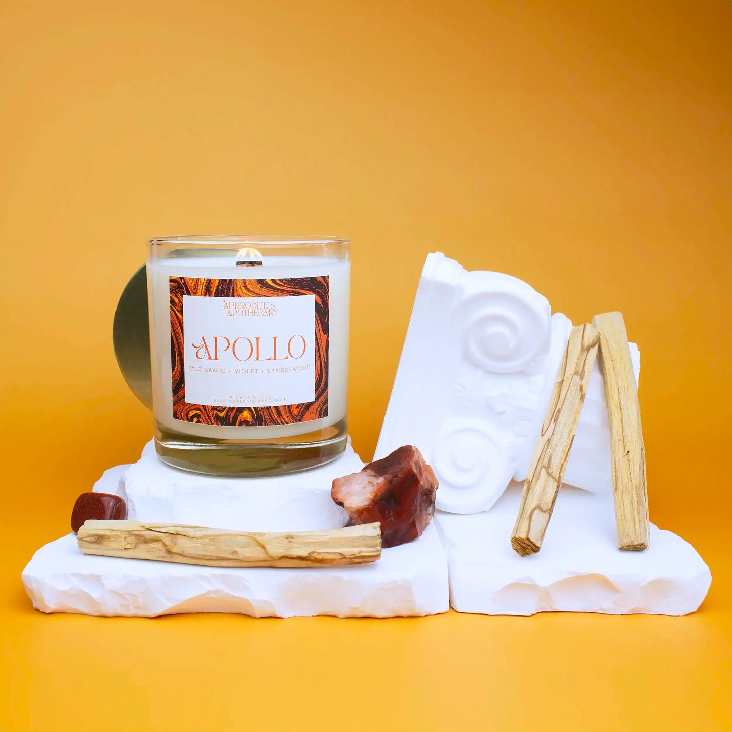 Apollo Candle 8.5 oz on a Greek themed photo set with bright yellow background