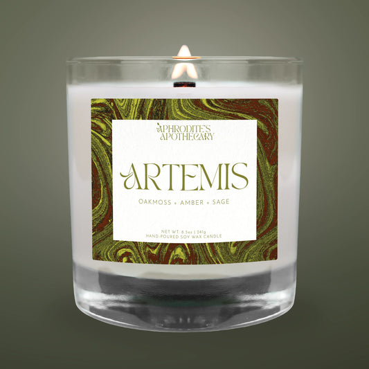 Candle with 'Artemis' label featuring marbled design on a dark background