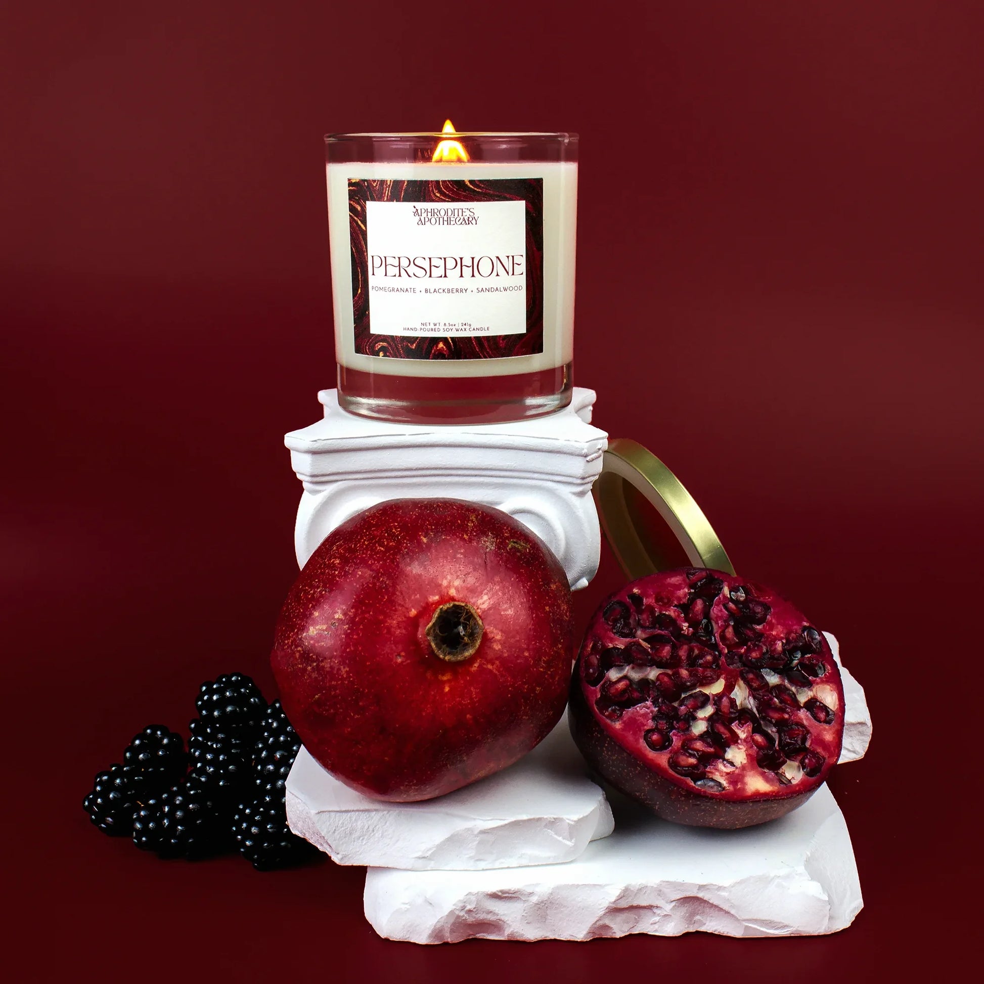 Persephone goddess candle with pomegranate and blackberries on Greek mythology altar