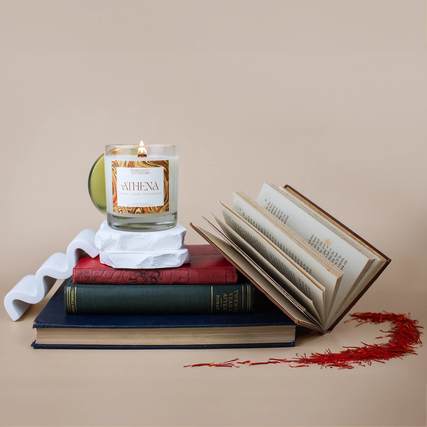 Athena Candle 8.5 oz on a Greek themed photo set with antique rare books and saffron stems